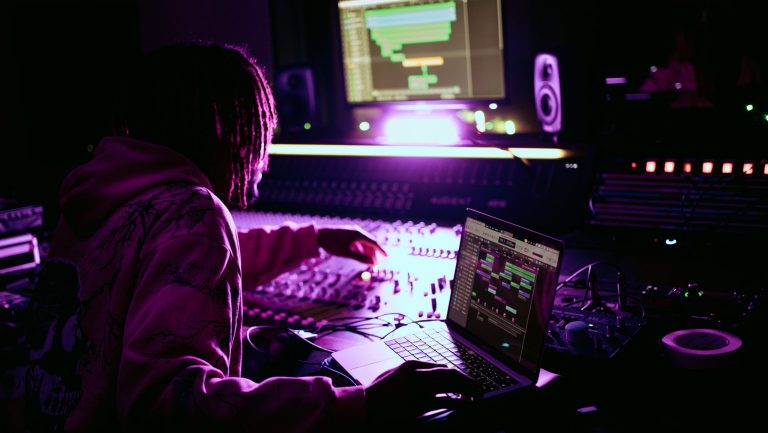 Shaun Chukwuma working in the studio with a purple illuminating the image